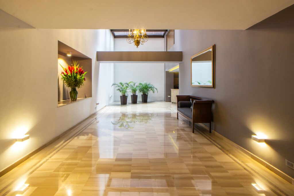 Luxurious hallway featuring marble flooring, decorative plants, and modern interior design.